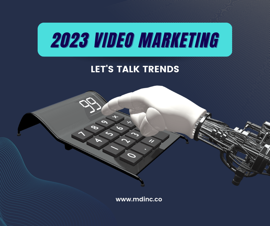 Blue background with a white-handed robotic arm clicking a computer for an article about What 2023 Has In Store for Video Marketing.